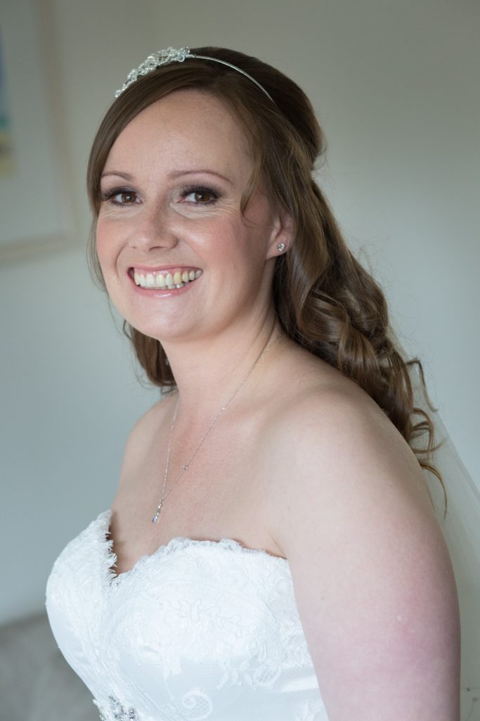 Bride looking at camera Soft glam bridal makeup with glowing skin by Chester bridal makeup artist Skin & Veil Bridal.