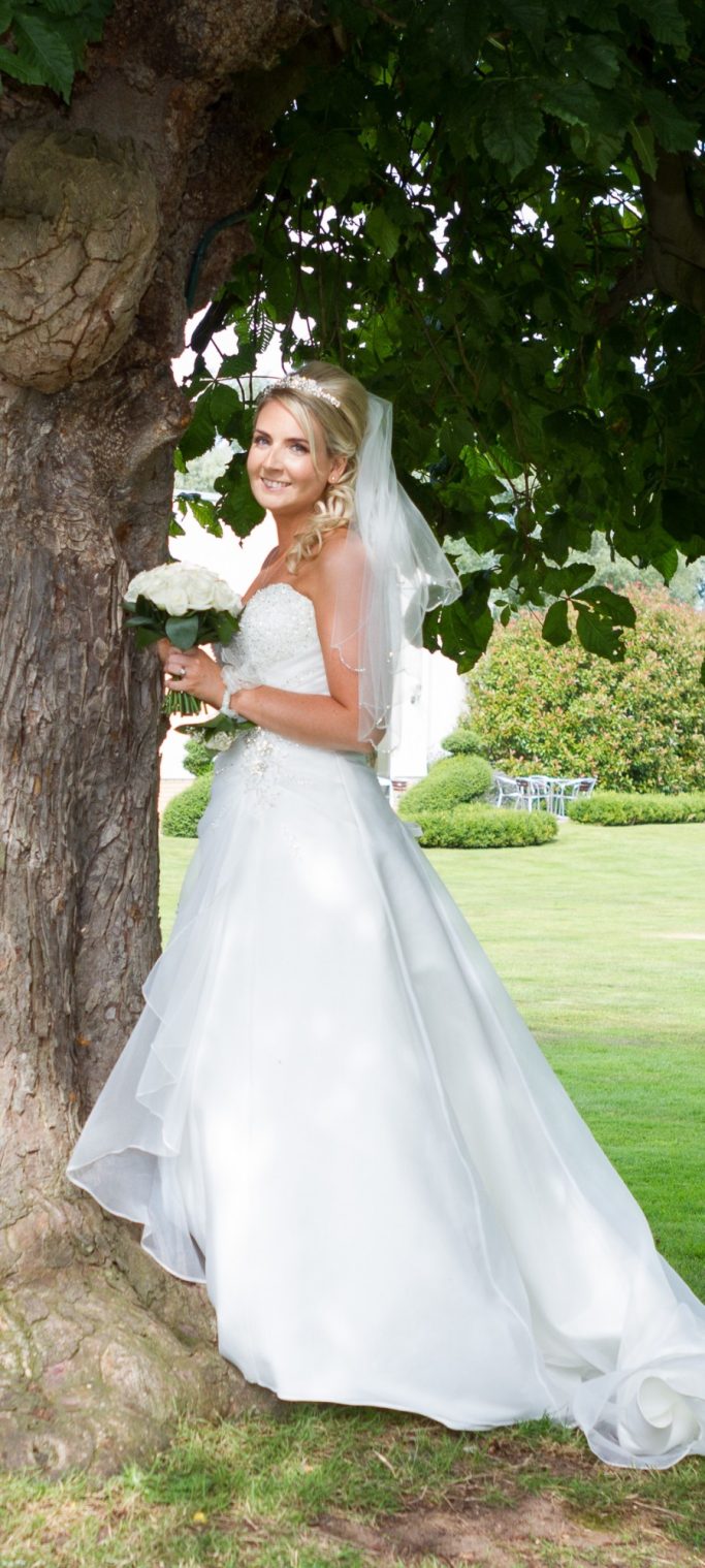 A bridal shot with a bouquet of flowers Luxury bridal makeup featuring soft glam eyes and luminous skin for Cheshire bride at Thornton Hall Hotel.
